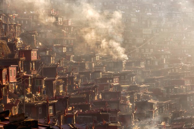 Hoogste meningsklooster in Larung-gar (Boeddhistische Academie) in een warme en mistige ochtendtijd, Sichuan, China