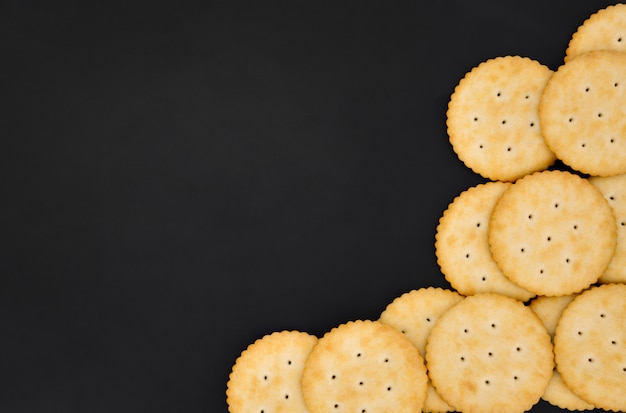 Hoogste meningsstapel ronde koekjes van de kaascracker met suiker op zwarte kleurenachtergrond