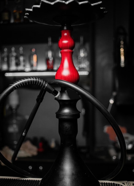 Кальян на темном черном фоне Кальян стоит на барной стойке в кальян-баре