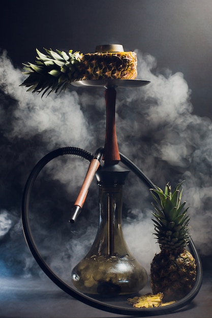 Фото Горячие угли кальяна на шаре кальяна с черной предпосылкой. стильный восточный кальян. ананас