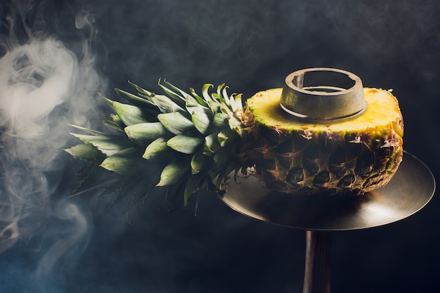 Hookah hot coals on shisha bowl with black background. Stylish oriental shisha. pineapple