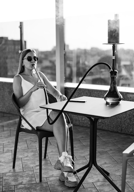 Hookah smoking by pretty lady Attractive young woman smoker Black and white shot