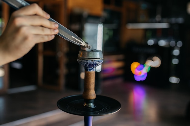 パーティーコンセプトでの水ギセル喫煙レストランのインテリアにある木製のテーブルの上に立つ水ギセル喫煙コンセプト伝統的な水ギセルスパーク水ギセルがテーブルの上で水ギセルをスパークします