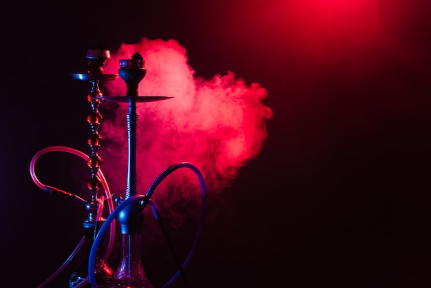 Hookah on a smoky dark room with neon lighting and smoke