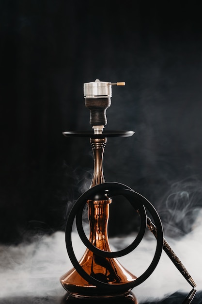 Hookah with smoke on a black background.