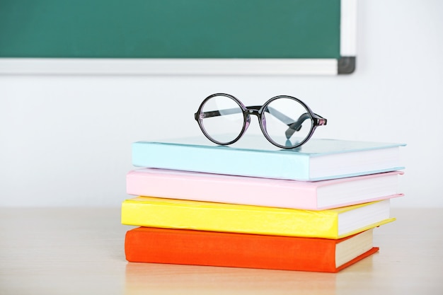 Hoop boeken en glazen op tafel in de klas