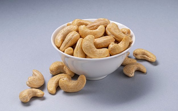 Hoop cashewnoten in kom op wit met kopie ruimte