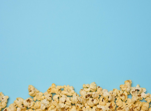Hoop gebakken popcorn met kaas op een blauwe achtergrond