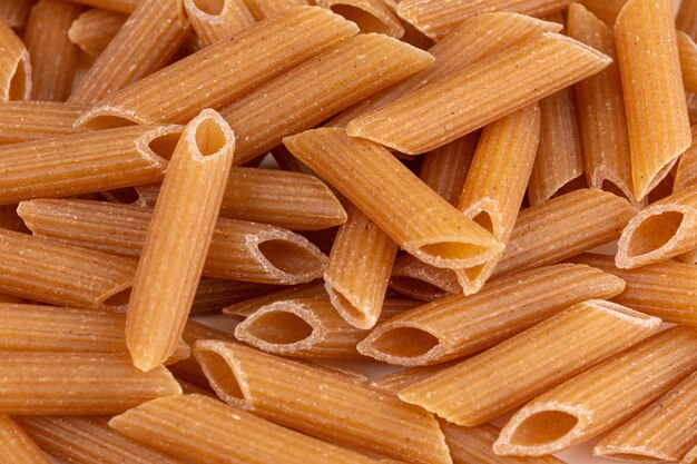 Hoop gegrilde penne volkoren pasta op wit