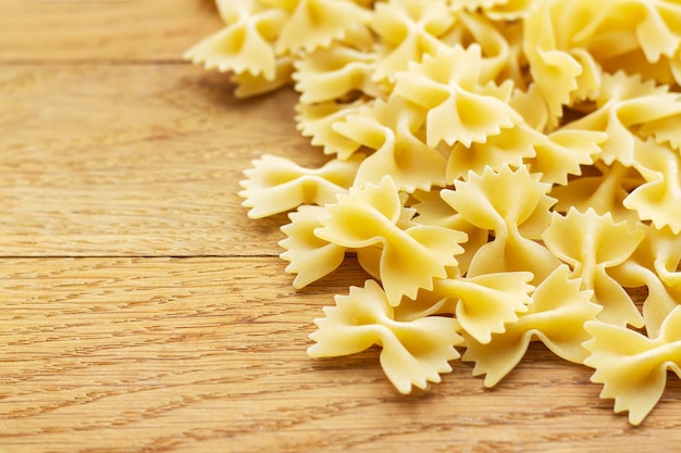 Hoop rauwe farfalle Italiaanse pasta op rustieke houten tafel