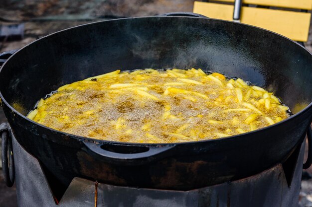 Hoop van de Franse frietjes die zich in een grote ketel voorbereiden