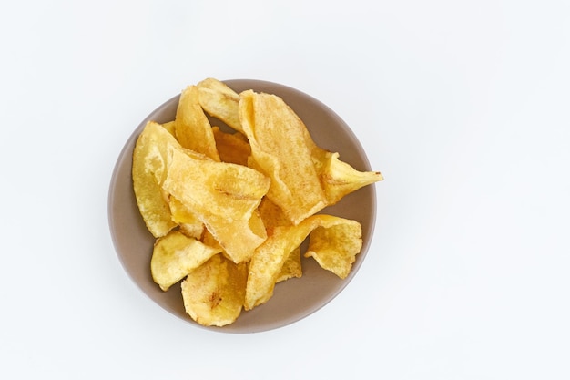 Hoop van gedroogde bananenchips snack op witte achtergrond Selectieve focus afbeelding