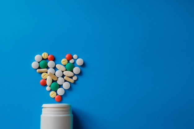 Hoop van pillen op blauw diverse farmaceutische geneeskundepillen, tabletten en capsules en fles op blauw