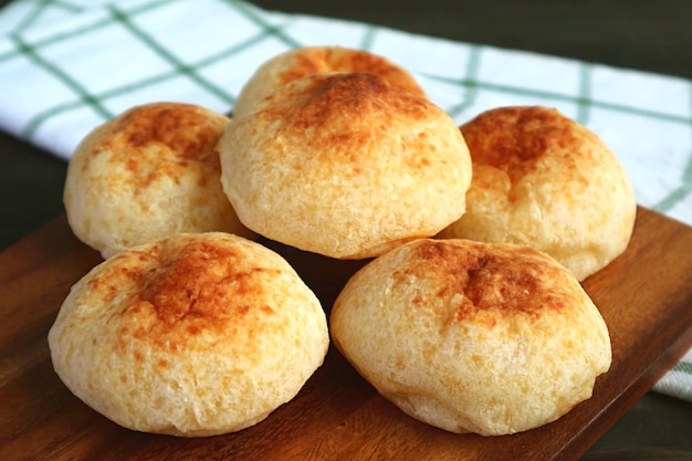 Hoop zelfgemaakte Braziliaanse kaasbroden genaamd Pao de Queijo op houten broodplank