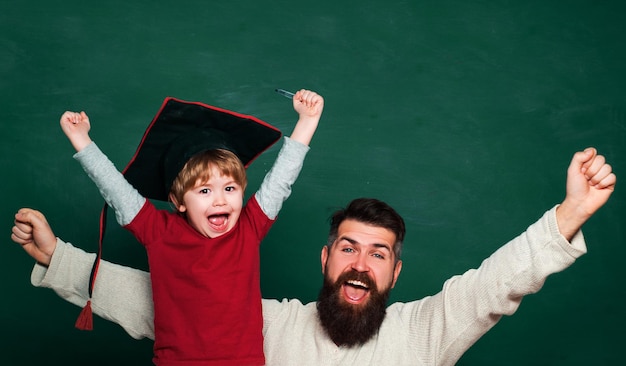 Hooray father teaching her son in classroom at school two generations young boy doing his school hom