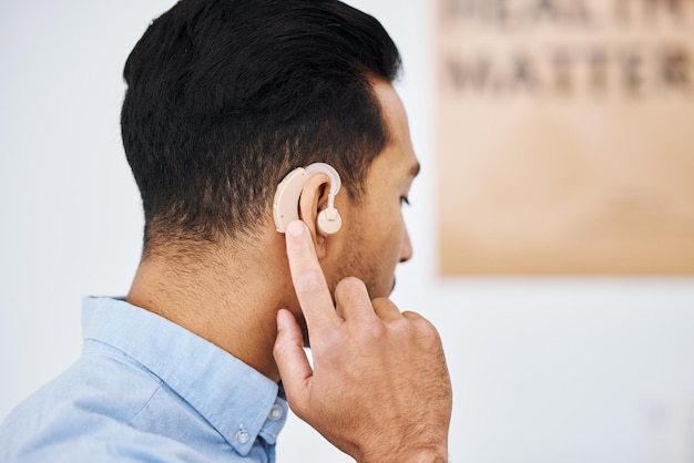 Hoortoestel doof en man met gehoorbeperking met medisch ondersteuningsapparaat als wellness-innovatie of audiologisch implantaat Patiënt auditieve en mannelijke persoon met een versterker voor hulp bij het luisteren