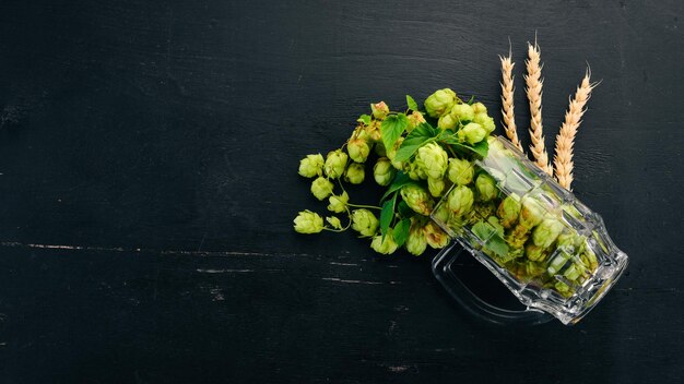 Hop en tarwe in een glas voor bier Op een oude houten tafel Vrije ruimte voor tekst Bovenaanzicht