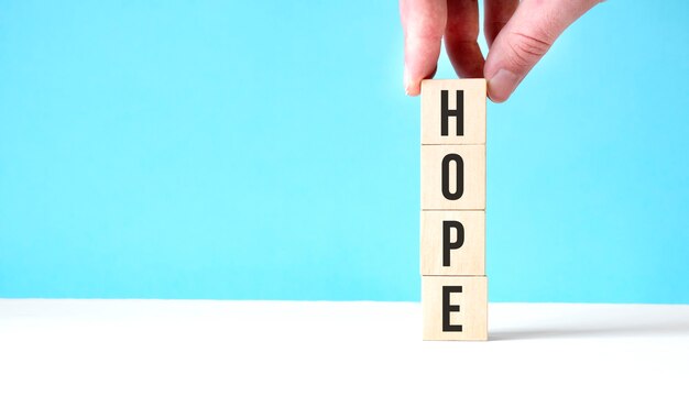 HOPE new year wooden cubes on blue table background with copy space for text. Business Goals, Mission, Resolution, New Year New You concept