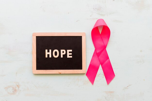 Photo hope text on wooden slate with pink ribbon over the wooden backdrop