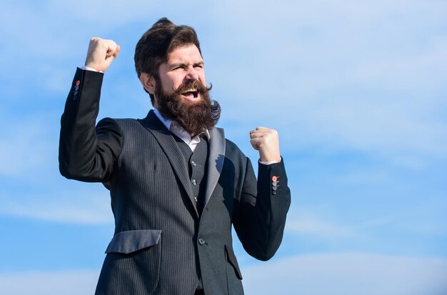 Foto fiducioso e fiducioso per il futuro l'uomo barbuto uomo d'affari ottimista indossa un abito formale sullo sfondo del cielo successo e fortuna stato d'animo ottimista pensa come ottimista essere ottimista festeggia il successo