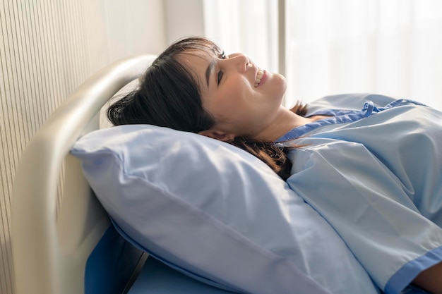 Hopeful and happy young patient woman in hospital healthcare and medical concept