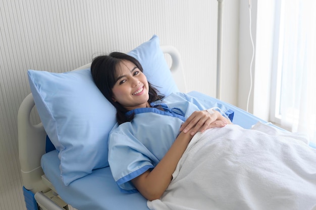 Hopeful and happy young patient woman in hospital healthcare and medical concept