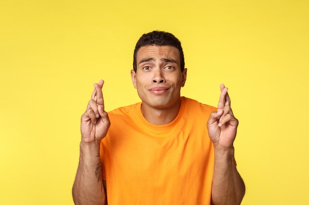 Hopeful worried young handsome man praying for wish come true