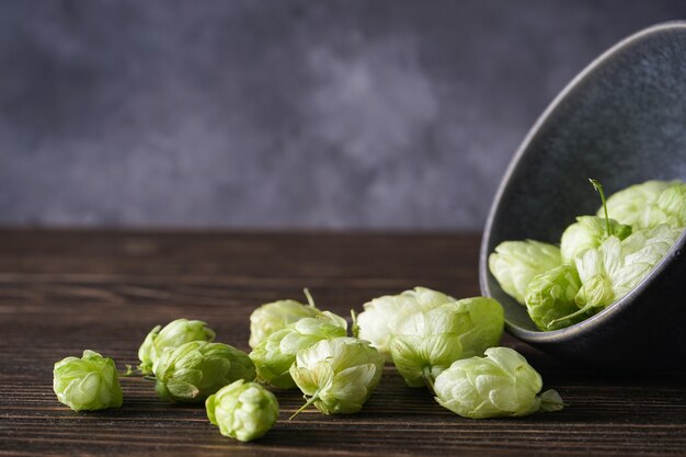 Hops in a bowl on a wooden space. place for text. Close-up.