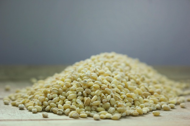  Hordeum vulgare seeds on wooden floor.