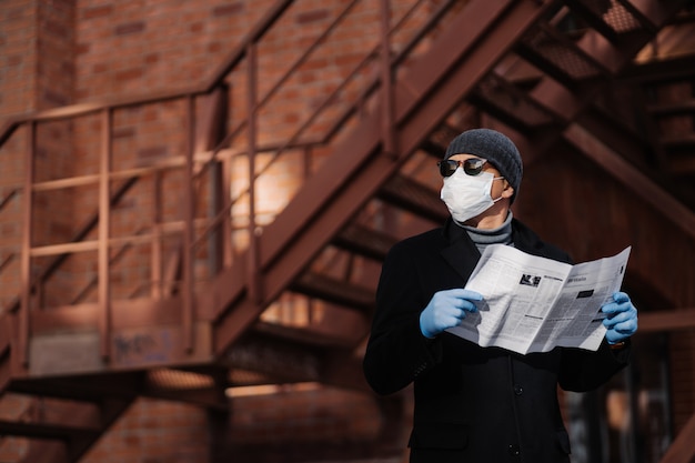 Horiontal shot of pensive man poses with newspaper