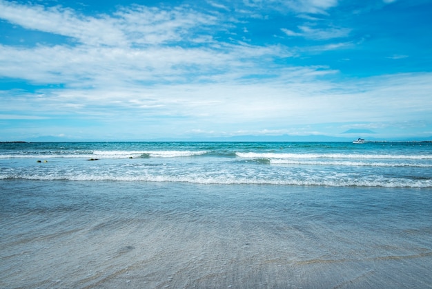 Horizon van de overzeese oceaangolf van het overzees op zand en blauwe hemelachtergrond