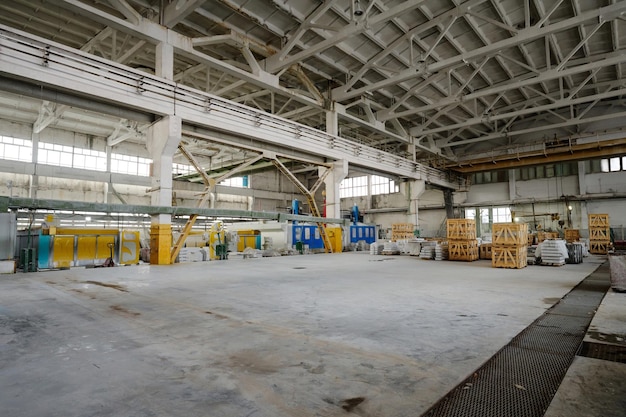 Horizontaal beeld van grote werkplaats met industriële machines en materialen voor productie