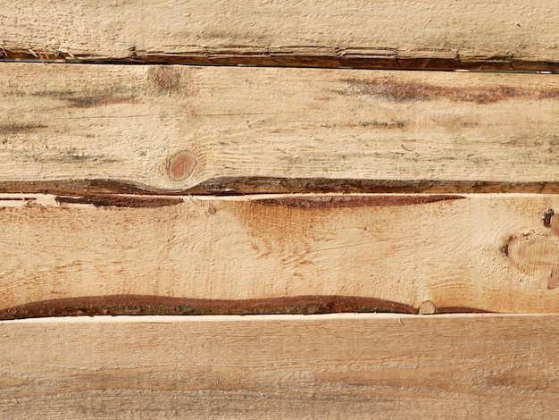 Horizontaal hout. Timmerhout van grenen planken. Ruw verwerkt grenen bord. Hout textuur. gat in de planken.