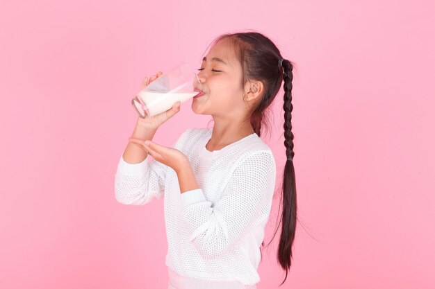 Horizontaal portret van een schattig mooi Aziatisch klein meisje met melkdoos geïsoleerd op de achtergrond