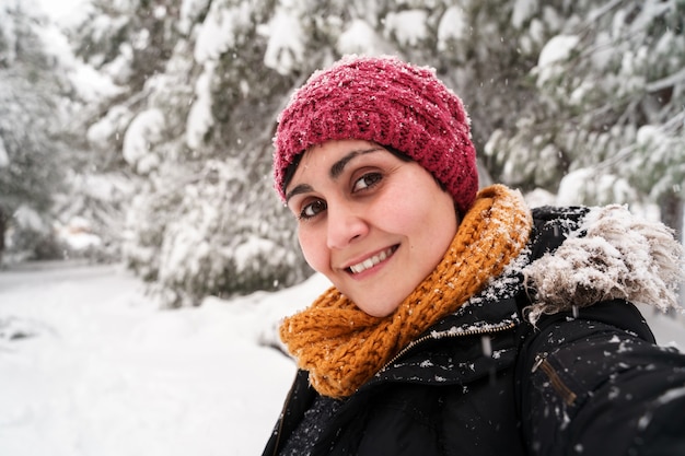 Horizontaal portret van jonge blanke vrouw die lacht inademen van frisse lucht buiten onder de sneeuw.