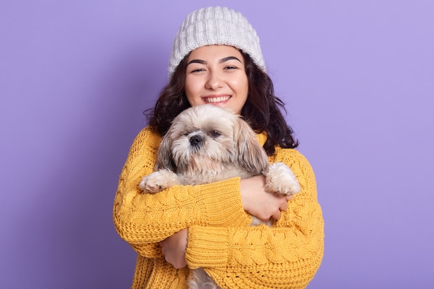 Horizontaal portret van teder leuk jong meisje dat haar hond in handen houdt