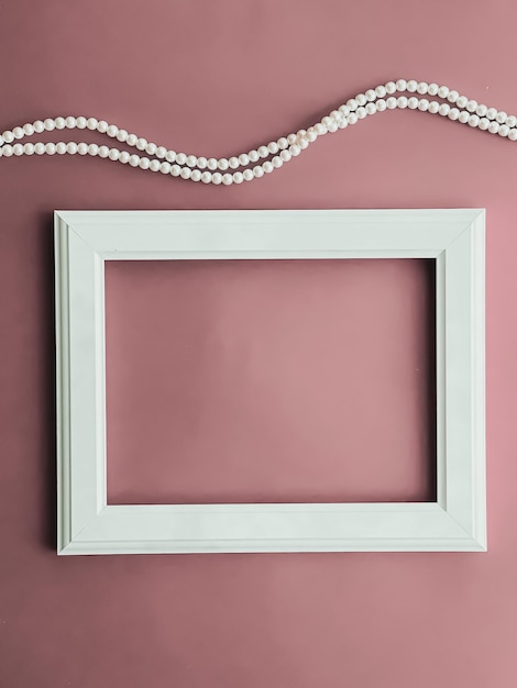 Horizontal art frame and pearl jewellery on blush pink background as flatlay design artwork print or photo album