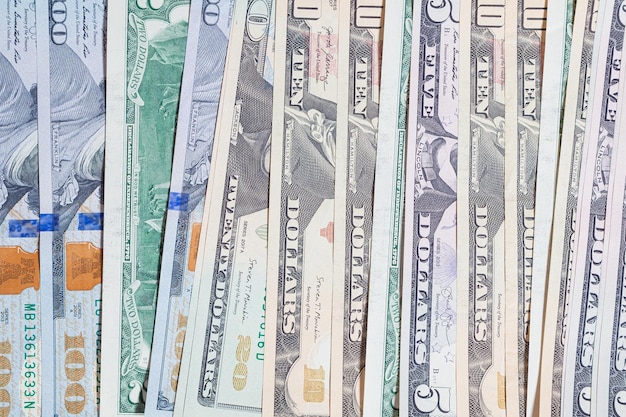 Horizontal background of spread out paper us dollars of different denominations