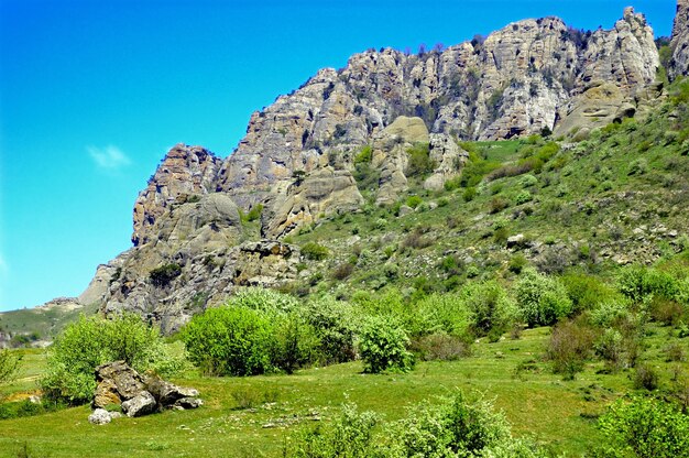 Горизонтальный фон с великолепным пейзажем Крымского полуострова Вид сверху на горы, покрытые пышной зеленью, и густые облака под пиками Чистое голубое небо Копирование пространства