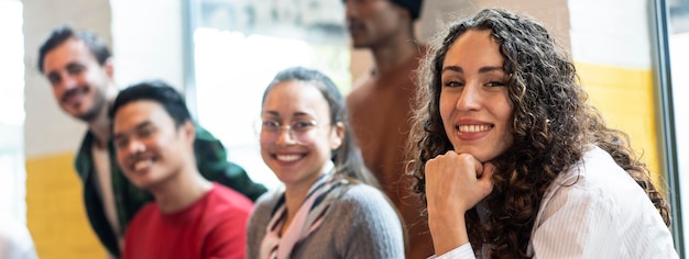 Horizontal banner or header with university students multiethnic team studying together on a new project in creative coworking classroom Bright filter with focus on first woman on left