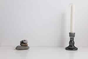 Photo horizontal composition of a candle in a candlestick and stones with a place for an inscription