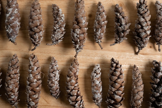 Photo horizontal flat lay of pine cones on a wooden table