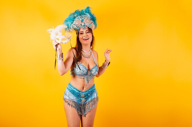 Horizontal half body shot beautiful brazilian woman in carnival clothes dancing with carnival mask