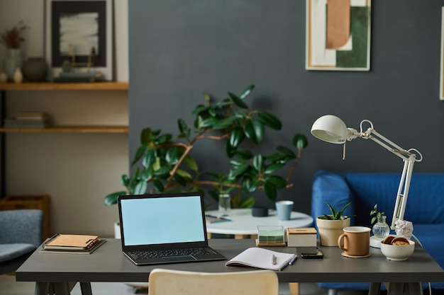 Photo horizontal image of workplace with laptop for online work in the room at home