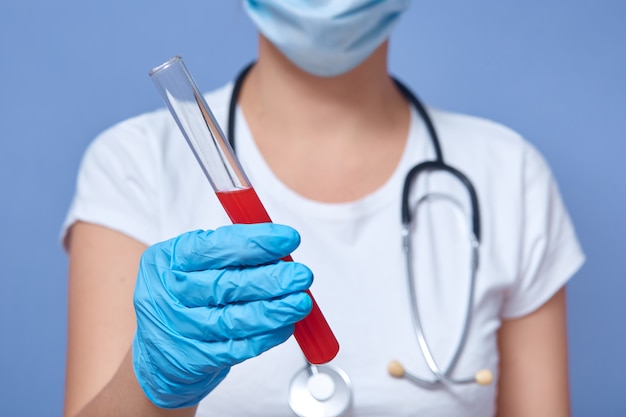 Horizontal indoor picture of unknown virologist holding test tube with blood of infected patient with covid19