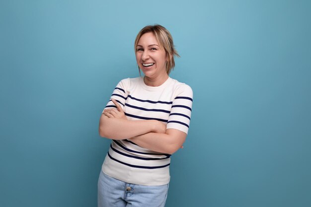 Horizontal photo of ardent energetic happy blonde woman in casual outfit smiling cute on blue