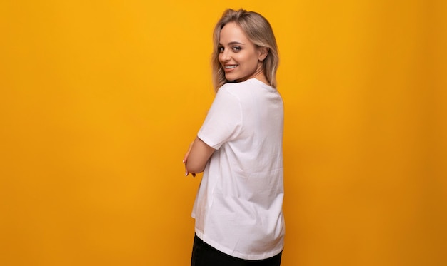 Horizontal photo of a blond girl with empty space on a yellow background