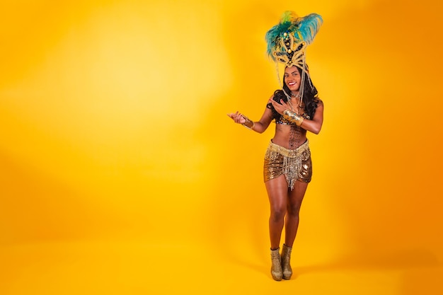 Horizontal photo full body black brazilian woman in carnival clothes showing something to the left