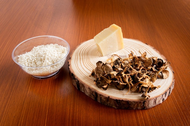 Photo horizontal photo ingredients to prepare a risotto with wild trumpets and parmesan food gastronomy