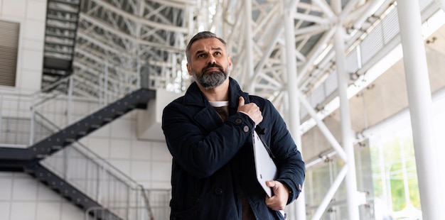 Photo horizontal photo of mature adult male boss with gray hair and beard walking on work site